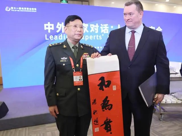 解放军中将赠送美前官员“和为贵”书法条幅在中场休息时，何雷送上一副中国书法条幅，上面写着三个大字“和为贵”